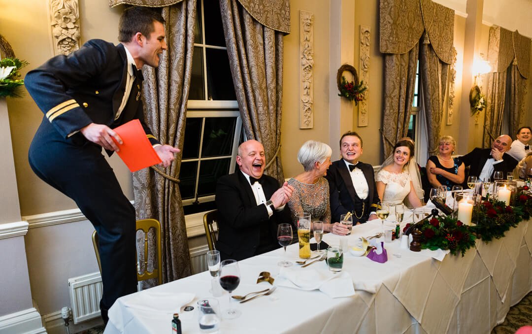 Best man standing on chair whilst making wedding speech