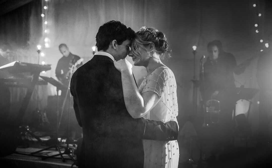Moody black and white photo of bride and groom at first dance