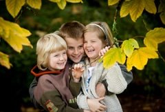 Portrait of kids laughing with autumn leaves