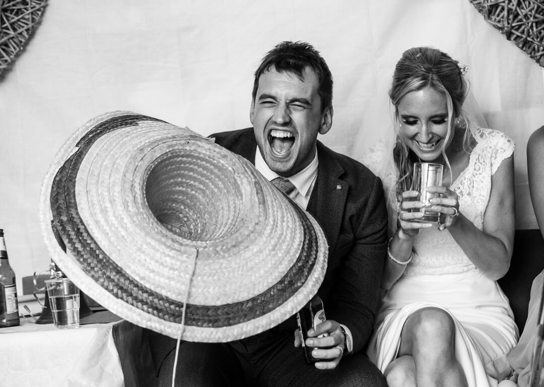 Groom with mexican hat laughing at speeches