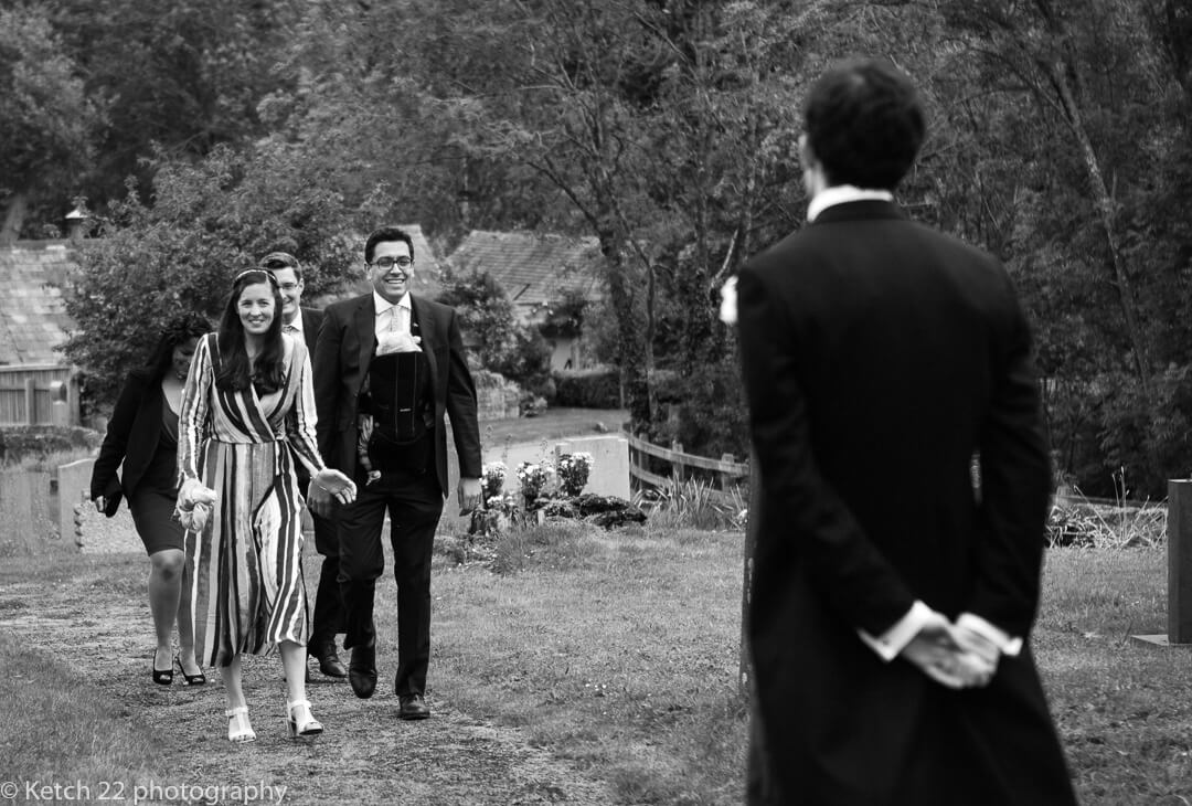 Groom greeting wedding guests just prior to ceremony