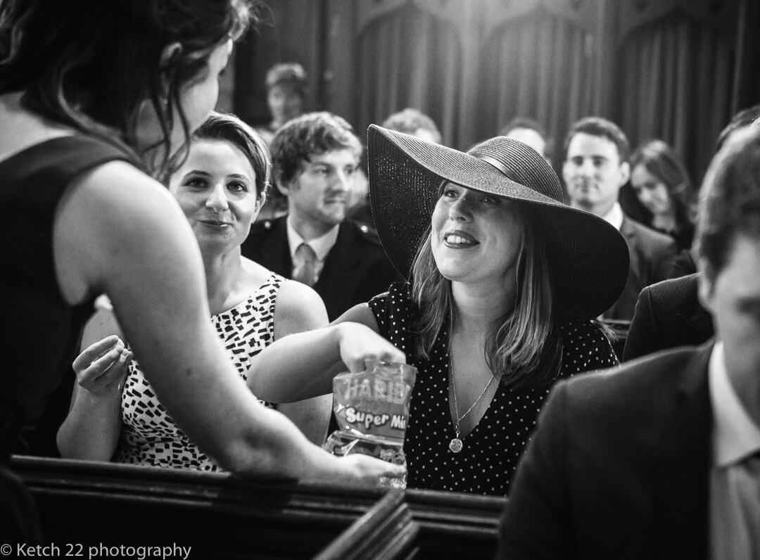 Wedding guests eating sweets at church ceremony