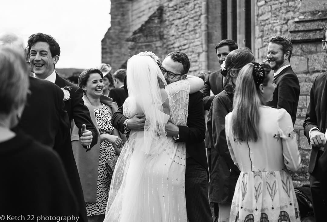 Bride hugging wedding guest outside church