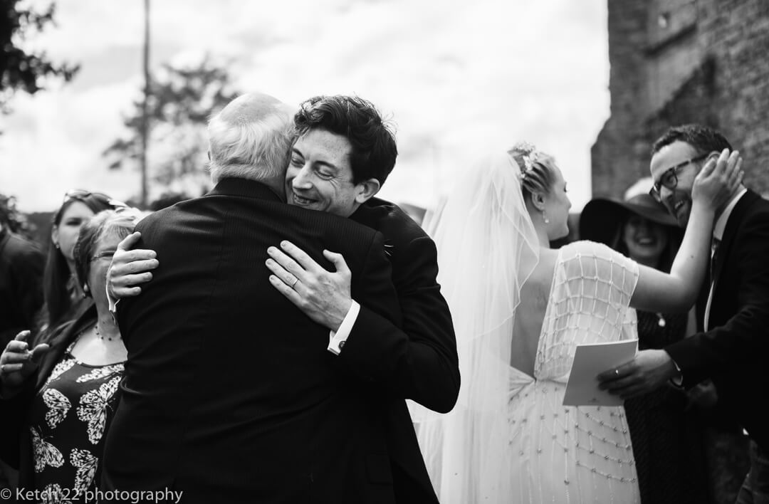 Groom hugging wedding guest after ceremony