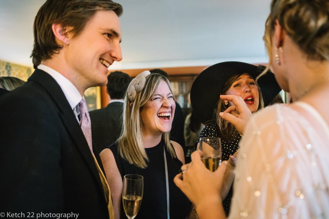 Wedding guests laughing and chatting at reception