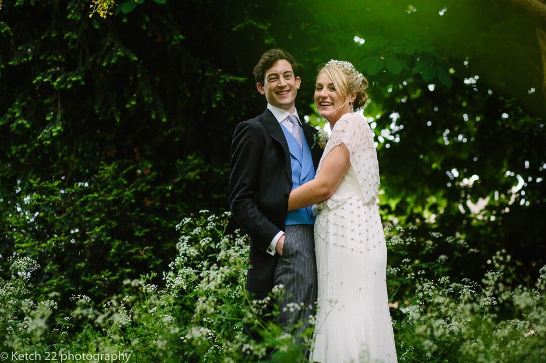 Portrait of bride and groom looking happy in garden