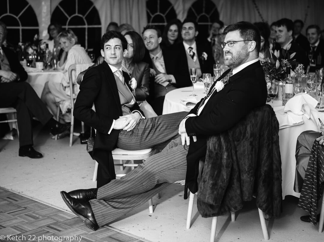 Groom and best man listening to wedding speeches