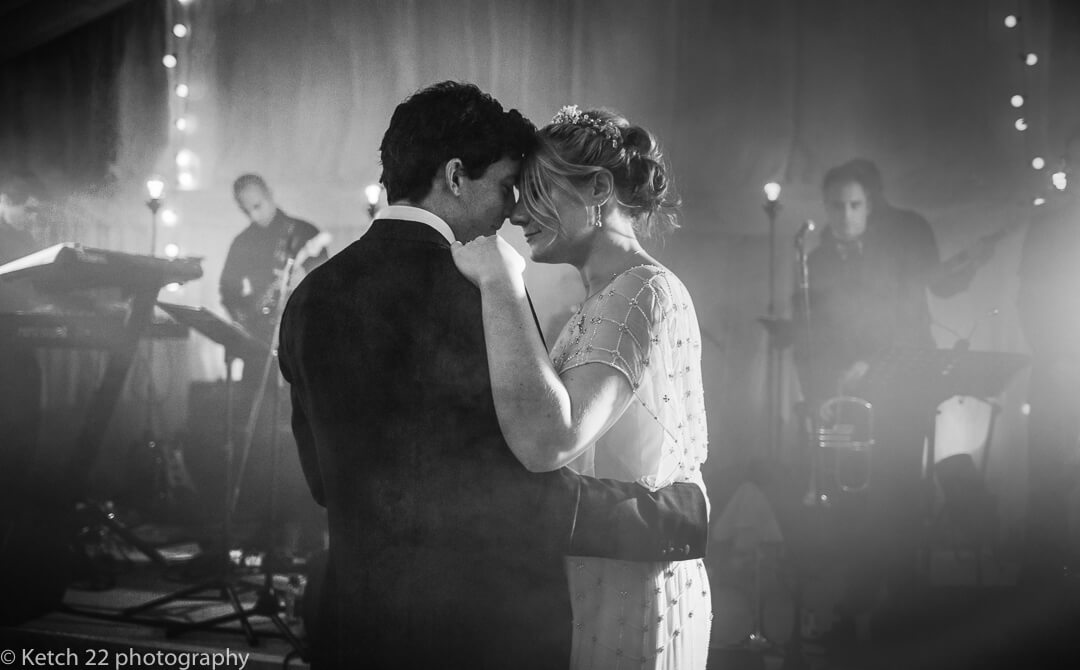 Moody black and white photo of bride and groom having their first dance