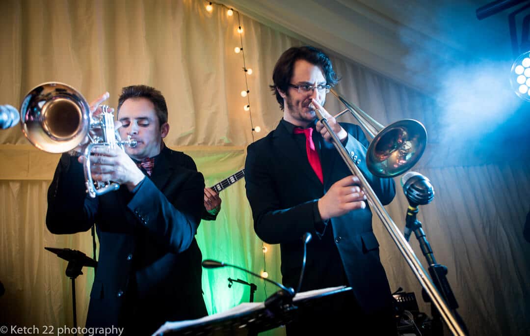 Saxophone and trumpet players in wedding band performing