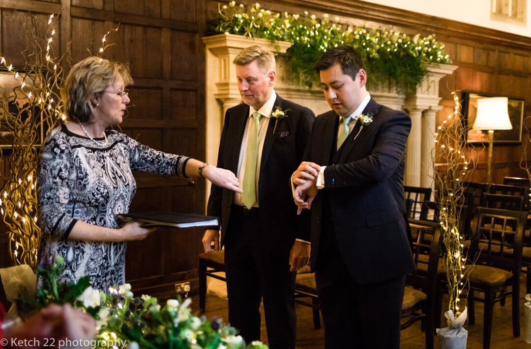 Groom and best man checking time before wedding ceremony 