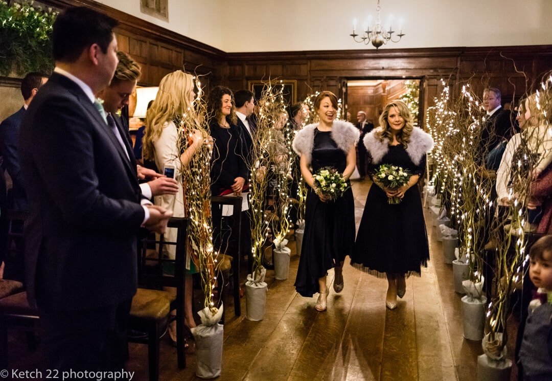 Bridesmaids walking down the aisle at winter wedding 