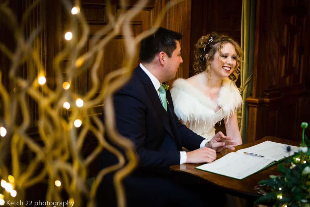 Bride and groom signing the registrar after Winter wedding ceremony