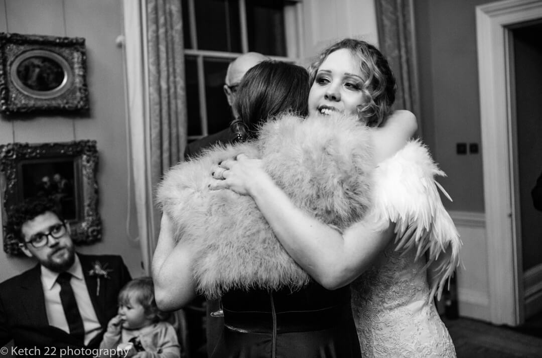 Candid wedding photo of bride hugging guest at North Cadbury Court