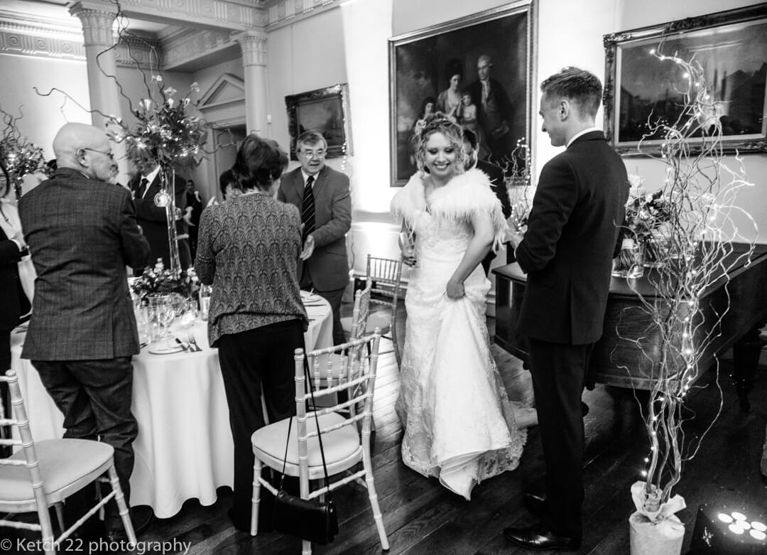 Photojournalistic wedding photo of bride entering dining room