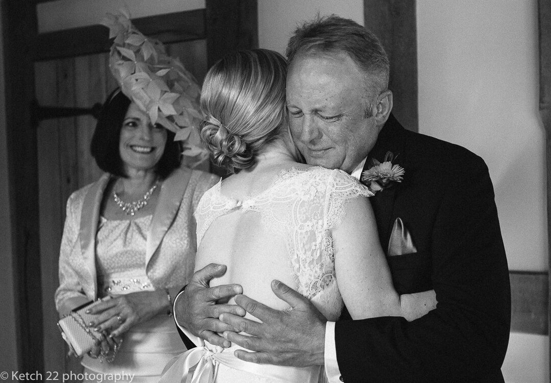 Storytelling wedding photography of bride giving her father an emotional hug 