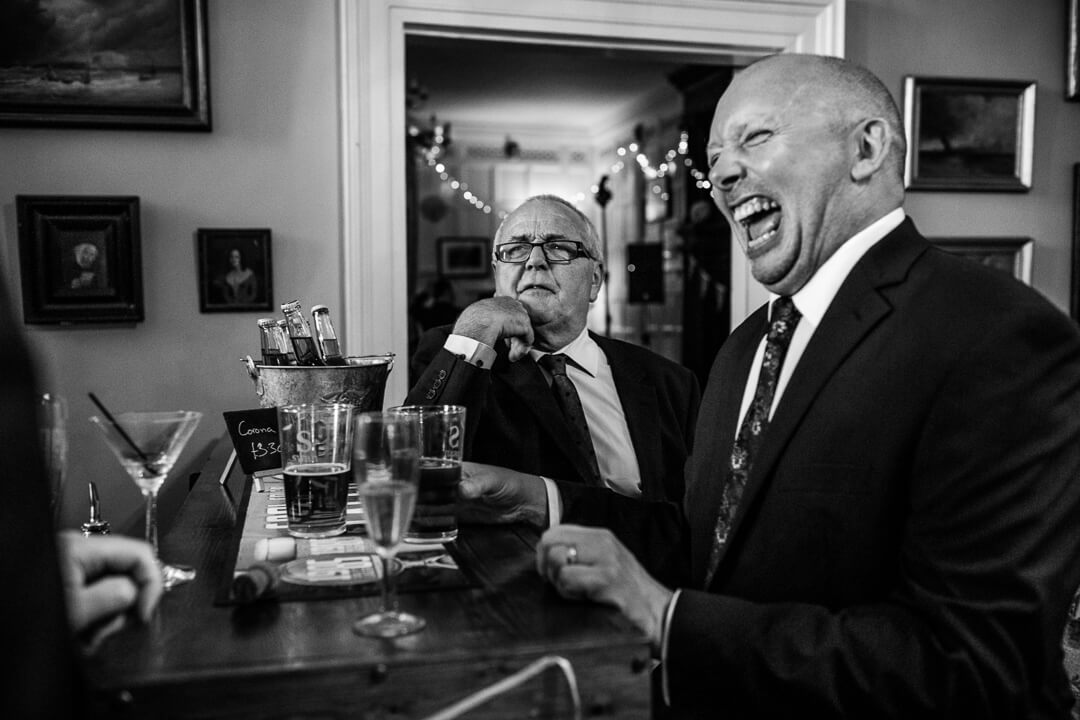 Wedding guests laughing at evening reception Herefordshire