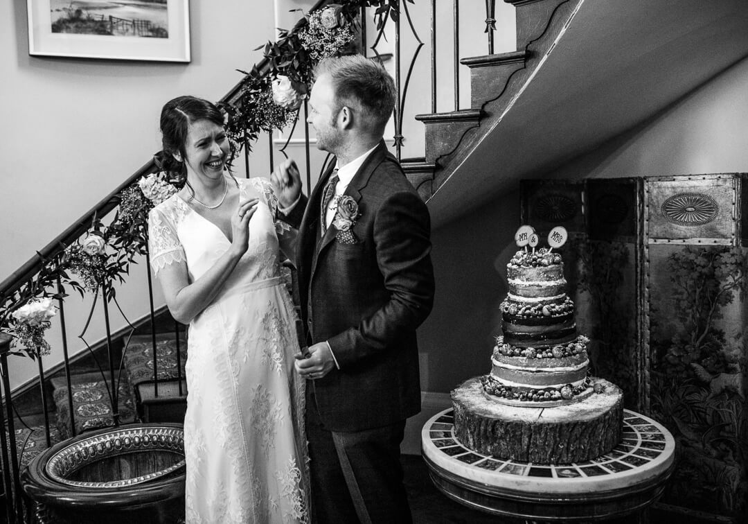 Bride and groom having a fun moment before cutting the wedding cake