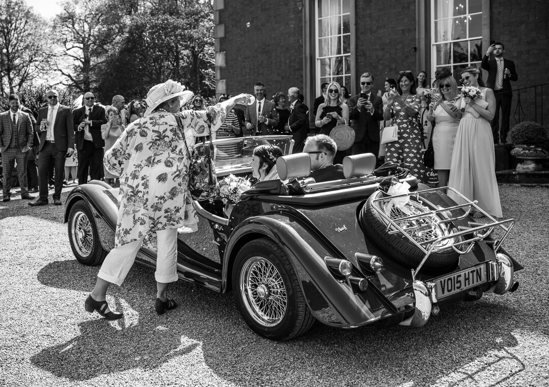 Wedding guest showering car with confetti