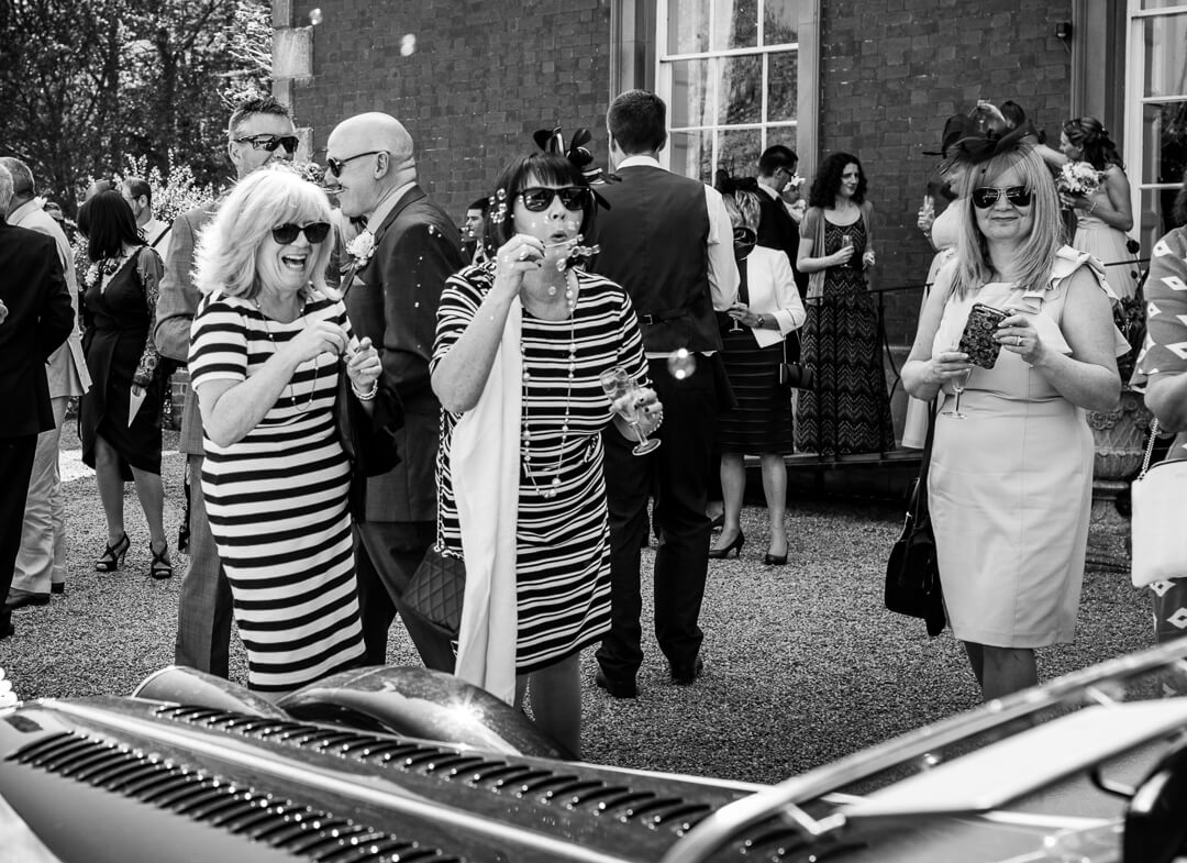 Candid photo of wedding guests blowing bubbles