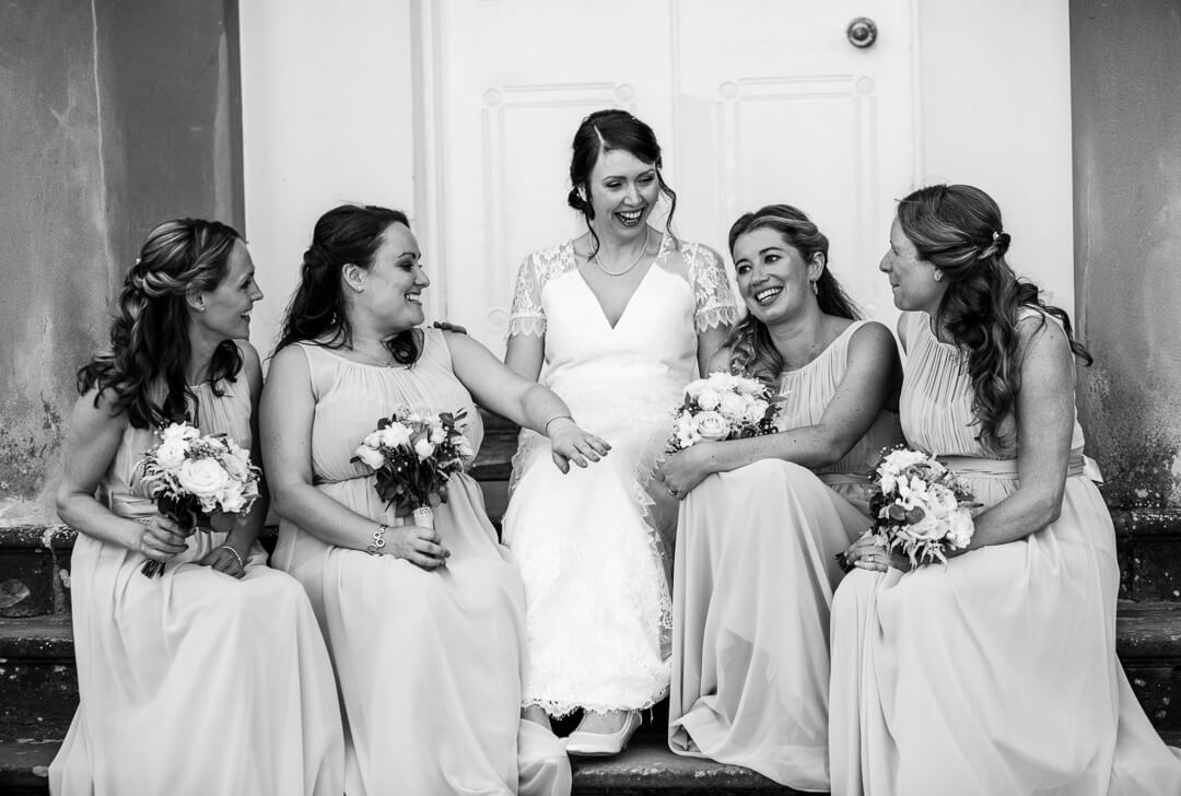 Bride and bridesmaids relaxing on steps at Homme House Wedding