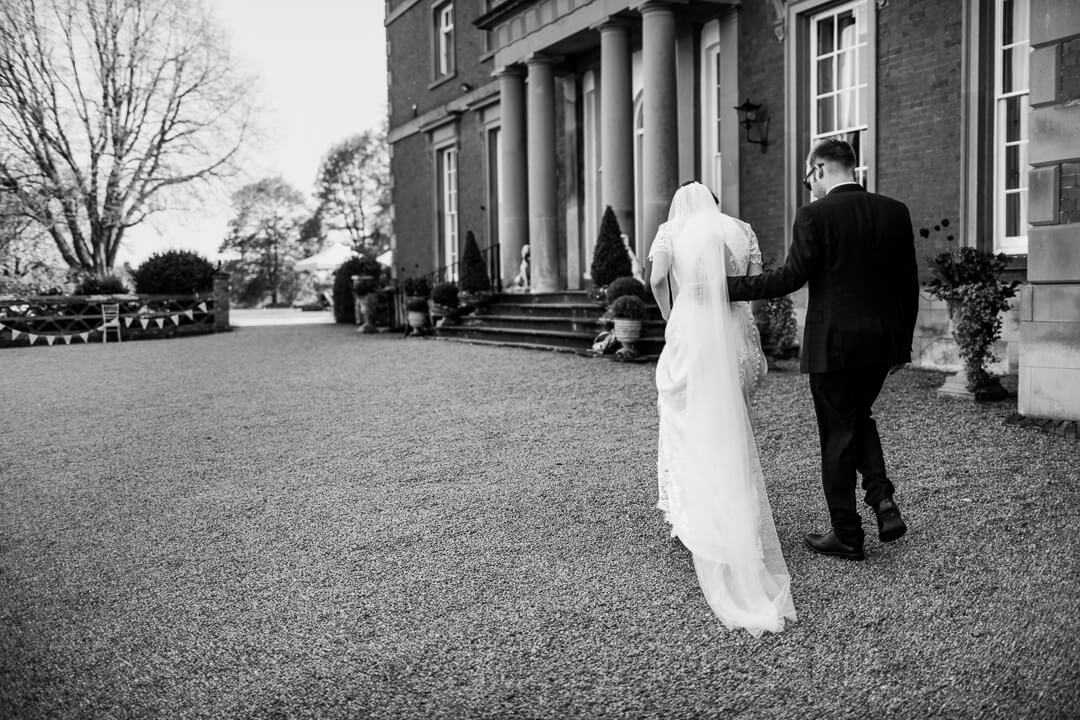 Bride and groom walking in front of venue at Homme House wedding