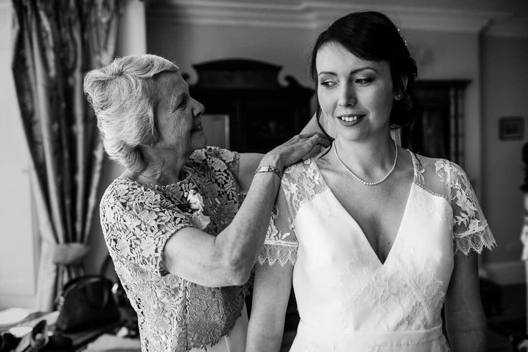 Mother of bride helping her daughter get ready at Country House wedding