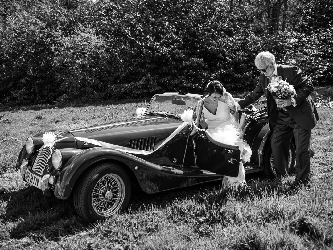 Bride getting out of wedding car