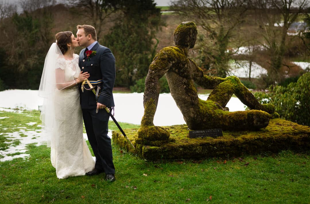 Bride and groom kissing in garden at Welsh winter Wedding