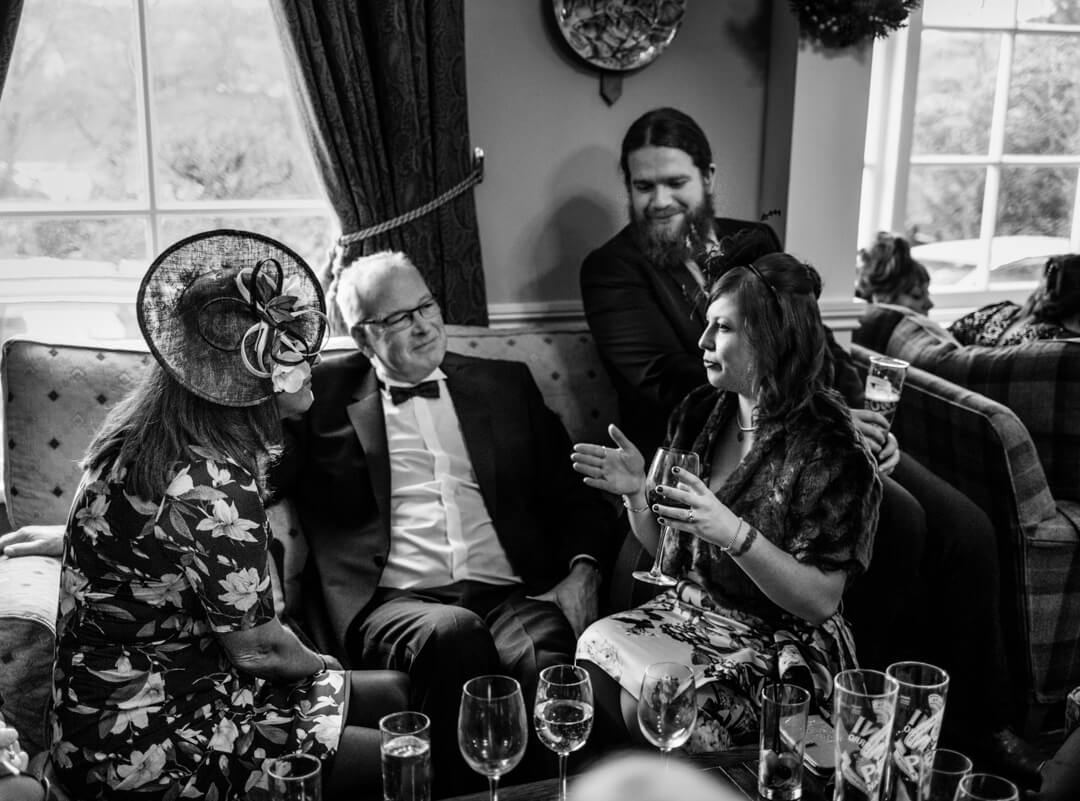 Black and white photo of wedding guests chatting