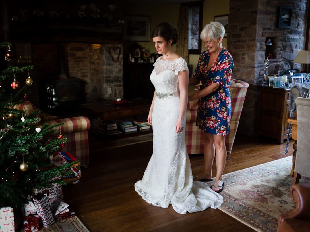 Mother helping bride with her wedding dress