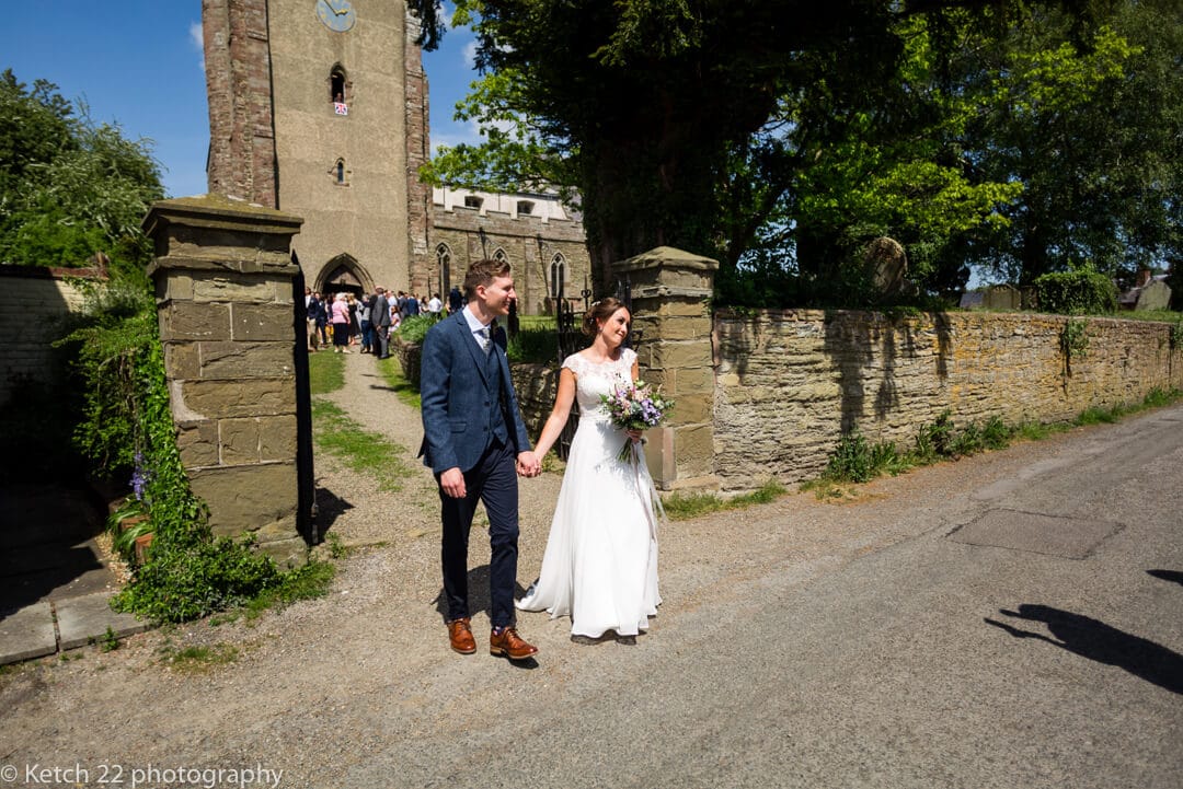 Bride and groom outside rural church after wedding