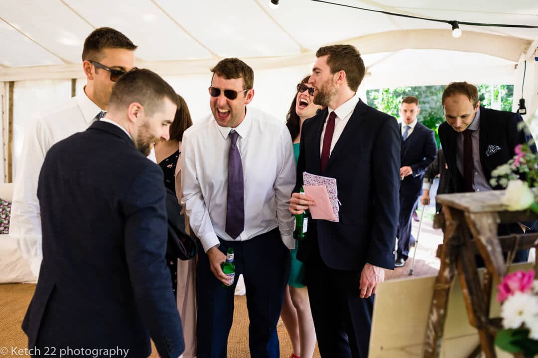 Wedding guests looking at seating plan and laughing