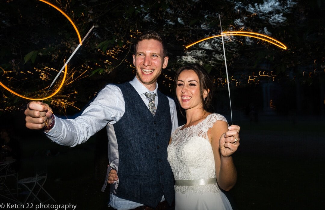 Portrait of bride and groom playing with sparklers