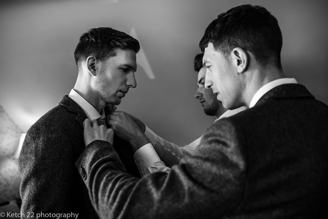 Best man helping groom at wedding preparations