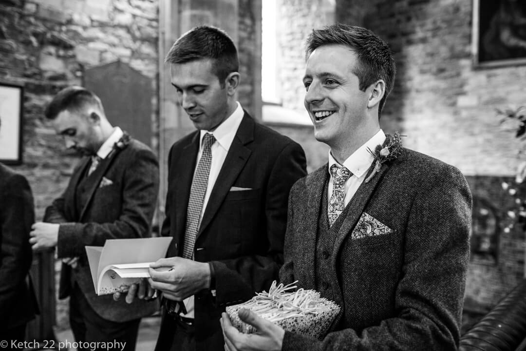 Groomsmen handing out order of service in church