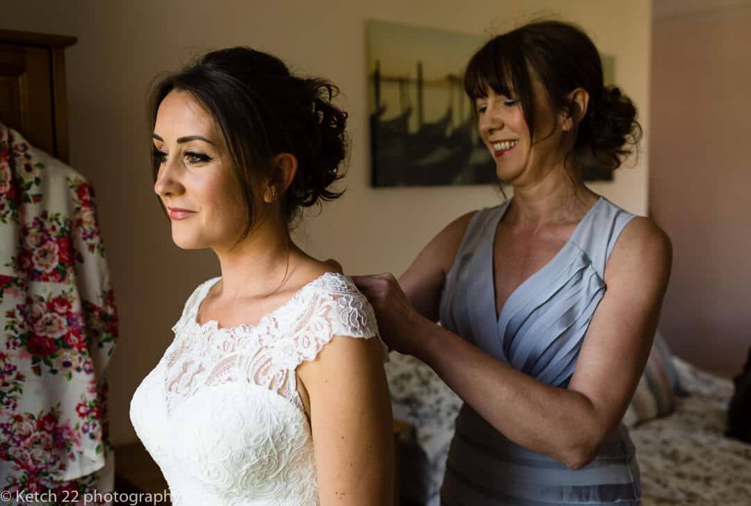 Mother helping bride get ready at wedding