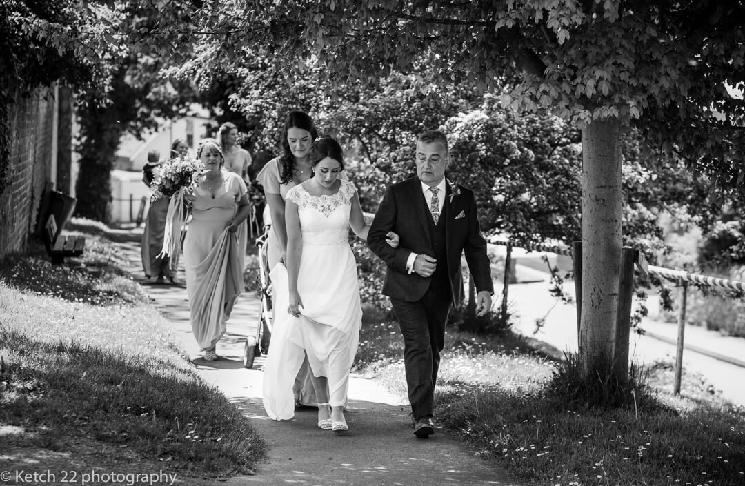 Bride and father walking to the Church at Marquee wedding