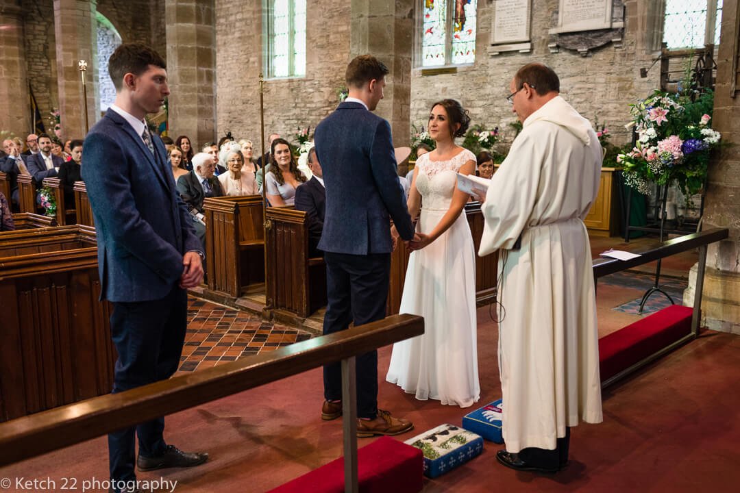 Vicar addressing bride and groom at Church wedding ceremony