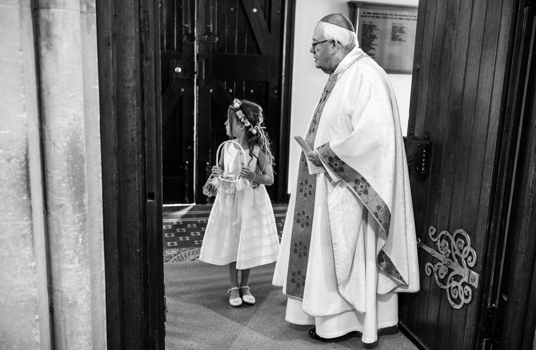 Priest and flower girl waiting for bride