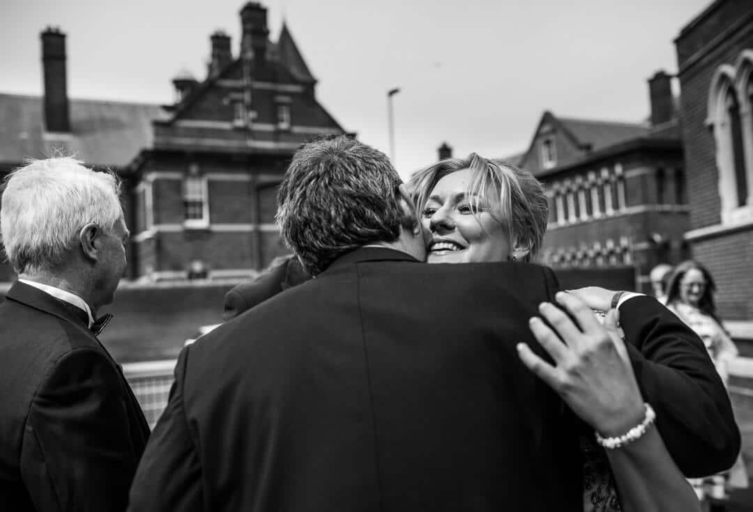 Bridesmaid hugging groom after wedding