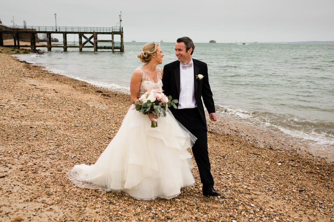 Bride and groom walking on beach at Portsmouth wedding