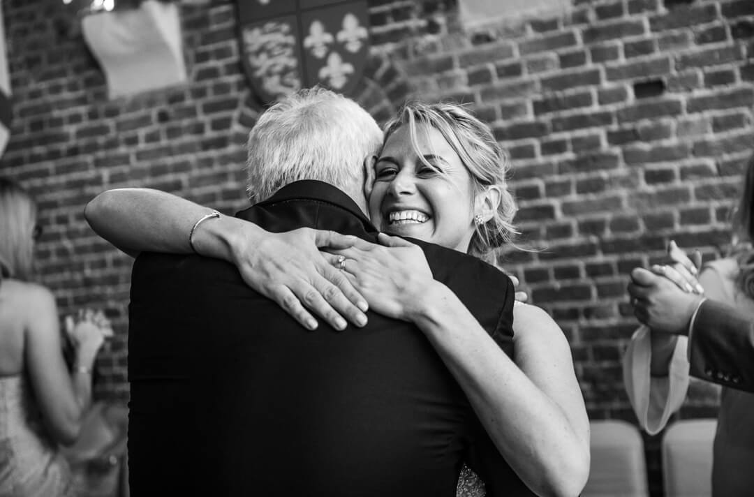 Bride hugging father at wedding reception