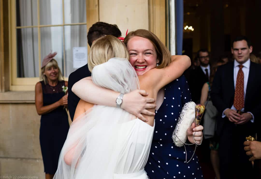 Wedding guest hugging bride at Piiville Pump rooms Cheltenham