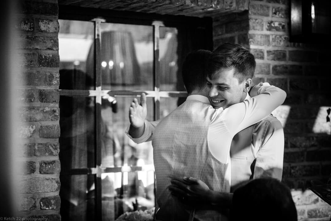 Groom hugging best man at speeches