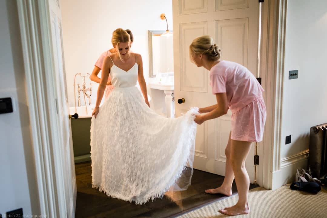 Bride putting on wedding dress