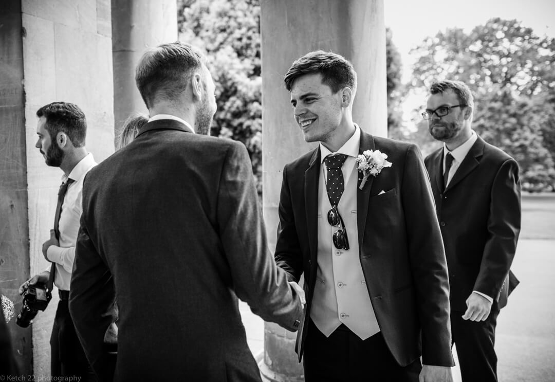 Groom greeting wedding guests