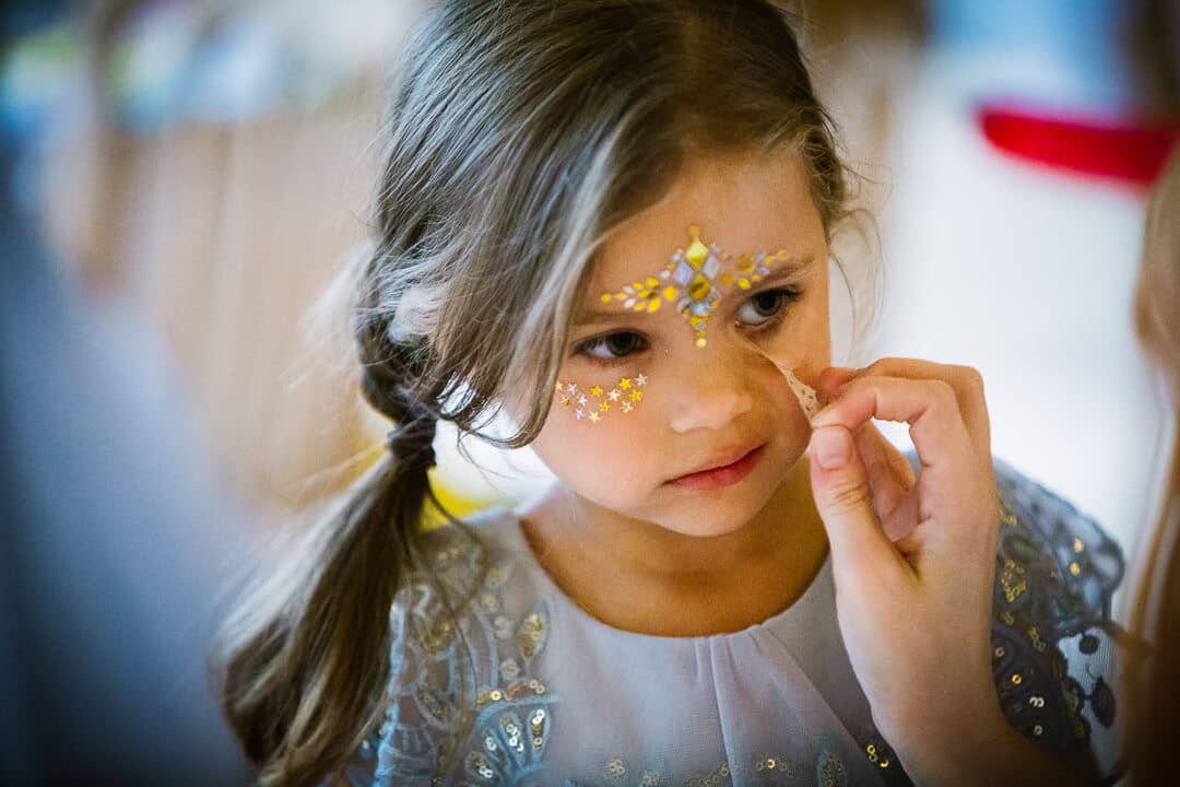 Flower girl having her face painted at Kingscote Barn Wedding