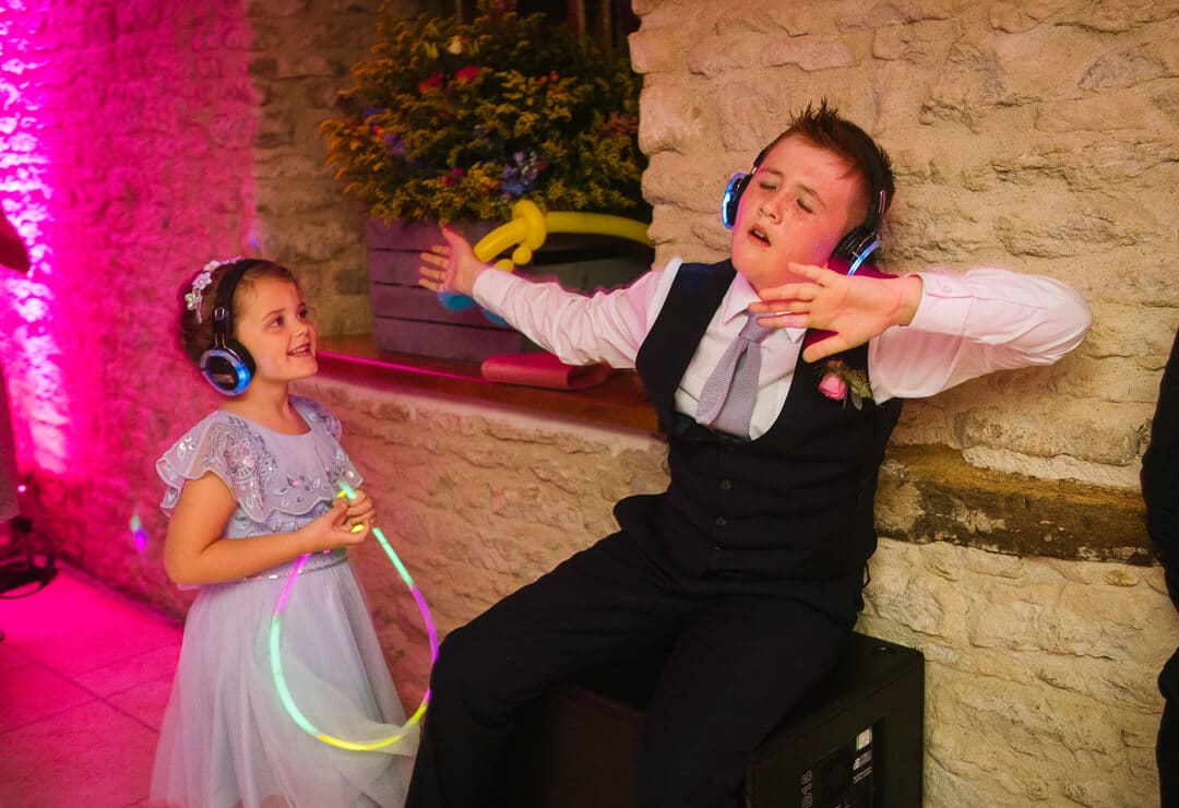 Page boy and flower girl dancing with head phones on