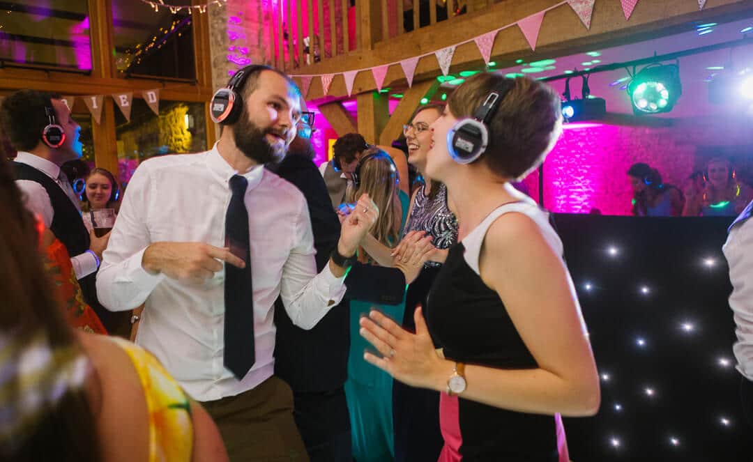 Wedding guests dancing at at silent party at barn wedding