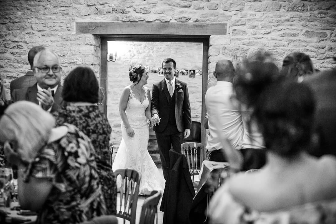 Bride and groom entering dining room at wedding reception 